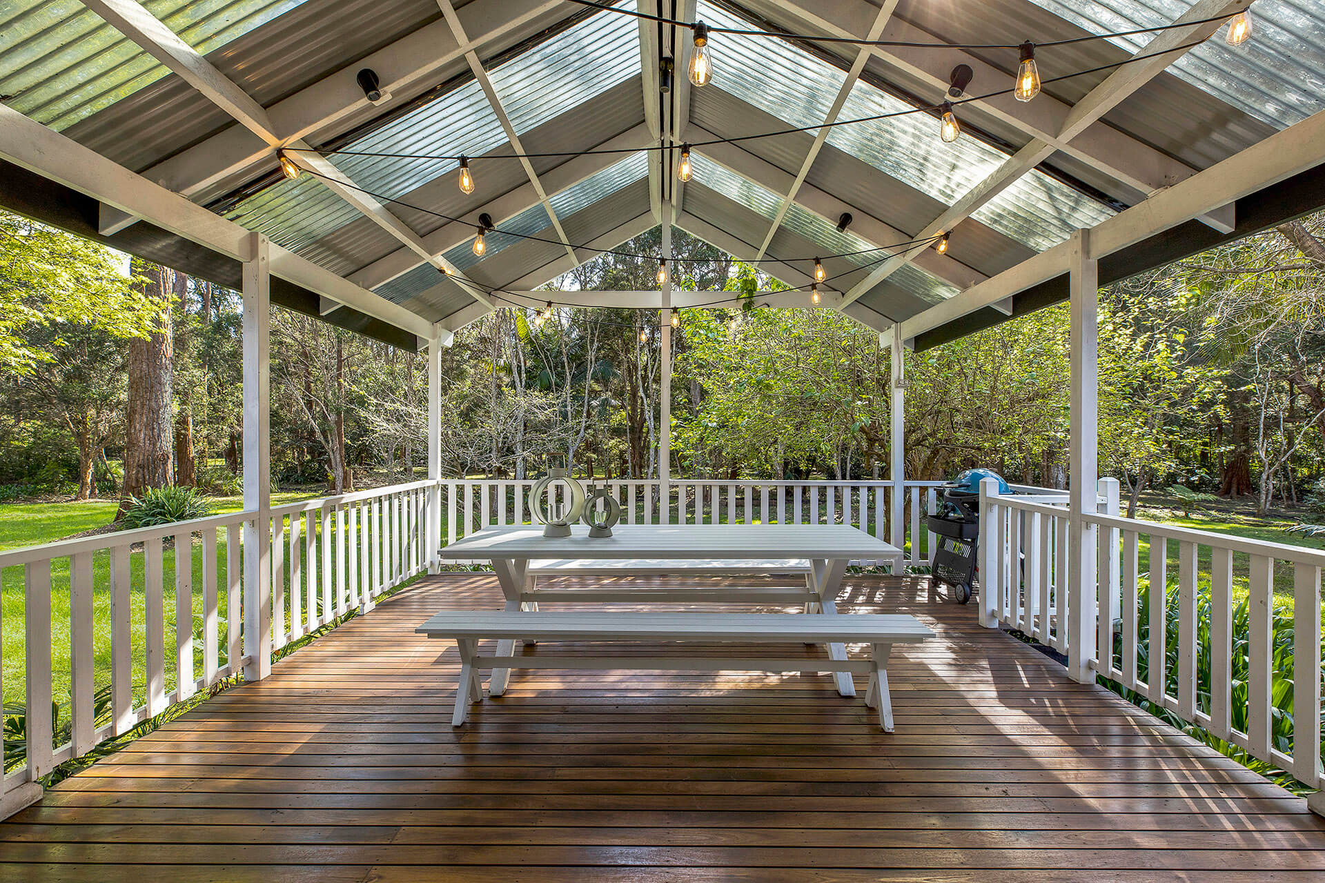 Outdoor patio with bench with bush in the background